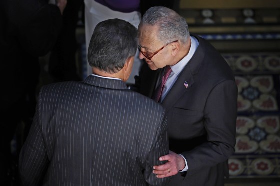 Sen. Joe Manchin, D-W.Va., left, talks with Senate Majority Leader Charles Schumer in the Eisenhower Executive Office Building on March 15, 2022.