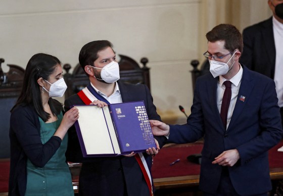 Image: Chilean President Gabriel Boric holds up the final version of the country's proposed, new constitution during a ceremony on July 4, 2022 in Santiago, Chile.