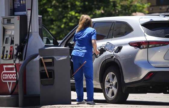 A motorist fills up the tank of her vehicle with gasoline at a pump at a Conoco service station on July 8, 2022, in Denver.