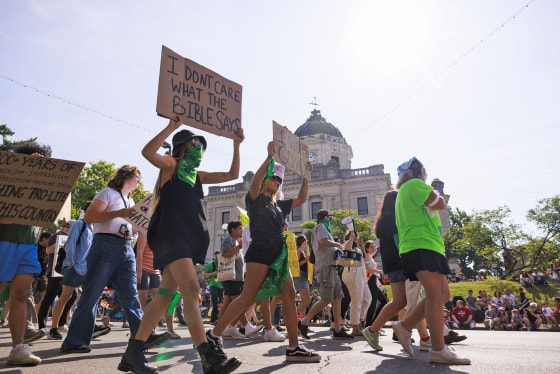 Abortion-rights demonstrators hold placards as they march
