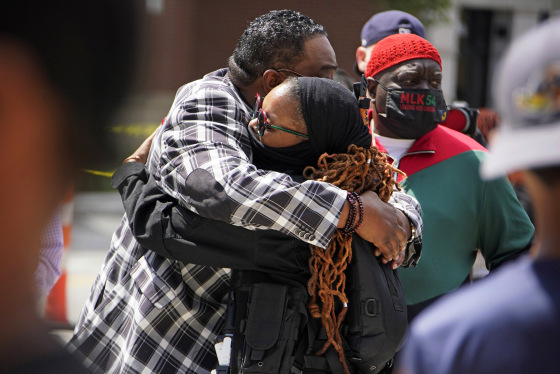 People hug outside the Akron Civic Center