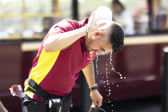 A man pours water over himself on Westminster Bridge