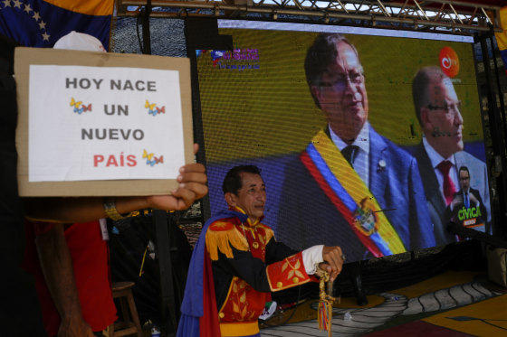 Supporters of Colombia's new president, Gustavo Petro, watch his swearing-in ceremony on a giant TV screen Sunday in San Antonio, on the Venezuelan border.