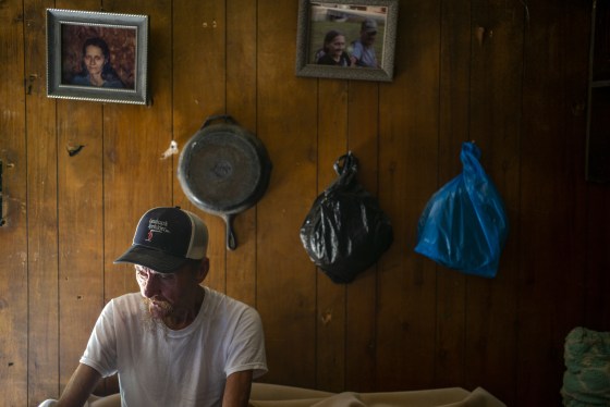 Dilbert White, 67, sits on the end of his cot where he’s been sleeping since his house was wrecked during the flooding in Caney, Ky. on Aug 3, 2022.