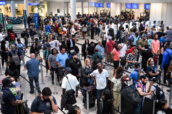 Travelers make their way through a TSA screening line at Orlando International Airport in Orlando, Fla., on July 1, 2022.