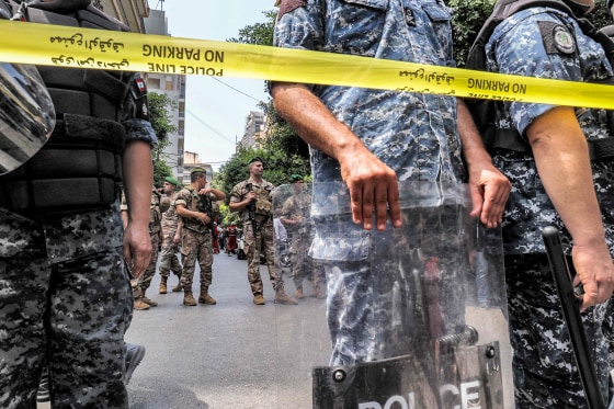 Army soldiers, rear, and security forces stand guard outside a Federal Bank branch in Beirut, Lebanon, on Aug. 11, 2022.
