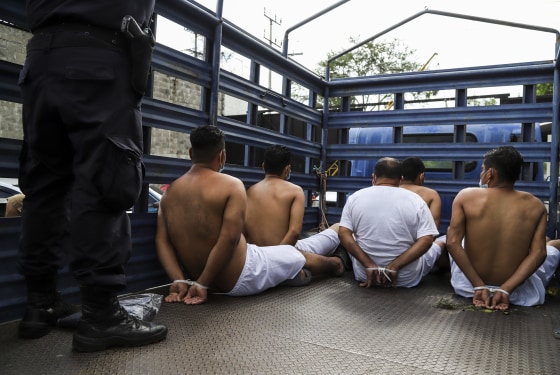 People arrested by police for having alleged links to gangs wait in zip tie handcuffs in the back of a truck to be transferred to a prison in Soyapango, El Salvador, on Aug. 16, 2022.