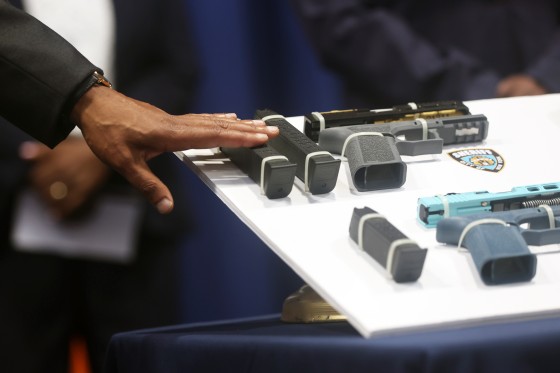 New York City Mayor Eric Adams touches a gun