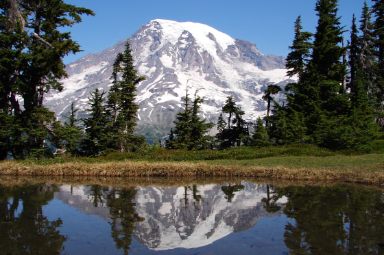 Mount Rainier reflected in a small lake at the top of Tatoosh Range.