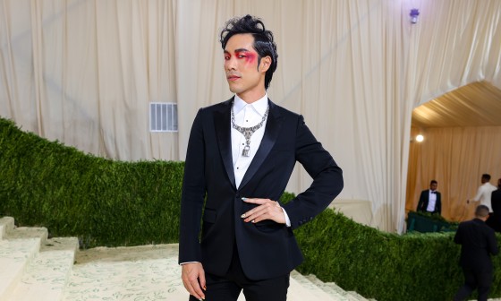 Eugene Lee Yang at the Met Gala, dressed in a suit and wearing expressive makeup.