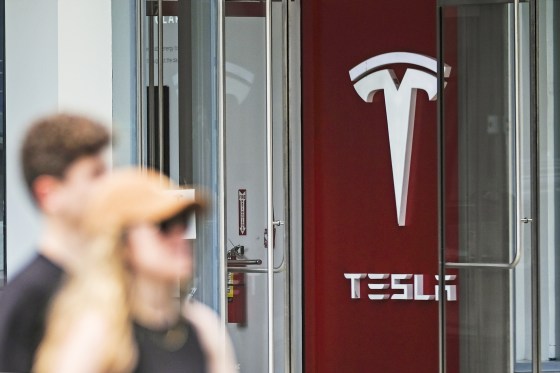 People walk next to the Tesla showroom