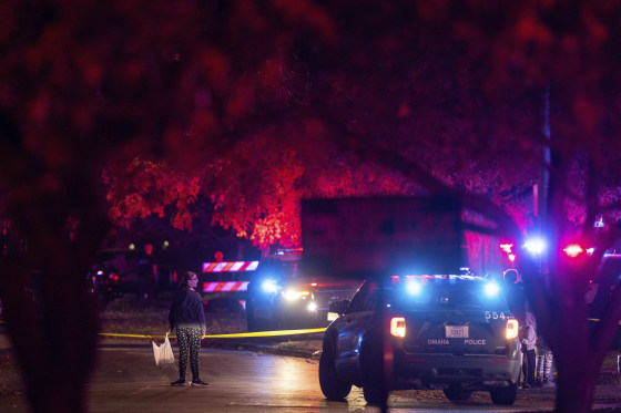 A woman walks by police tape after Omaha police shot a man who drove through a barricaded area during a neighborhood Halloween celebration late Monday.