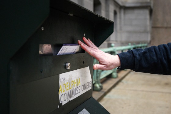 A voter casts their ballot at a drop box outside of Philadelphia