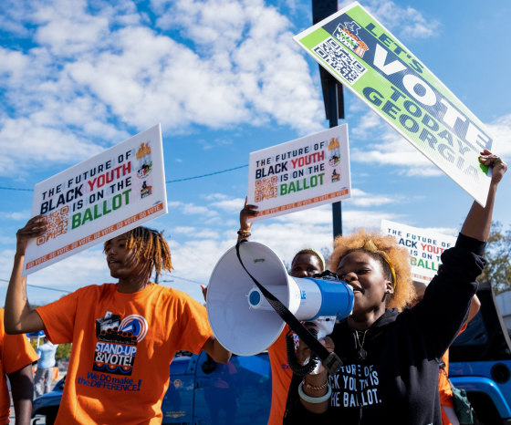 People rally to encourage voter turnout across from a polling location