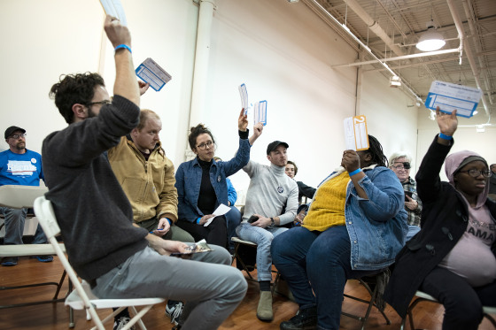 Attendees for Senator Bernie Sanders, an Independent from Vermont and 2020 presidential candidate, hold up their Presidential Preference Cards during the first-in-the-nation Iowa caucus at the Southridge Mall in Des Moines, Iowa, U.S., on Monday, Feb. 3, 2020. Iowa Democrats prepared to pack firehouses, schools and community centers across the state Monday night to give the first read in the race to challenge President Donald Trump in November.