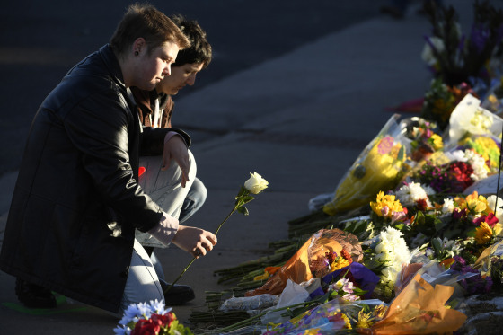 Ren Kurgis, left, and Jessie Pacheco, leave flowers at a makeshift memorial near Club Q in Colorado Springs, Colo., on Nov. 20, 2022. 