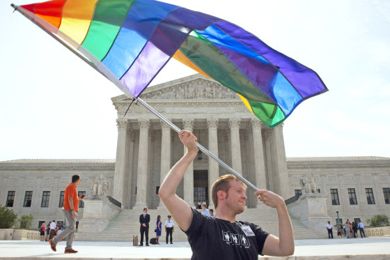 A person waves a rainbow flag in support of gay marriage outside of the Supreme Court