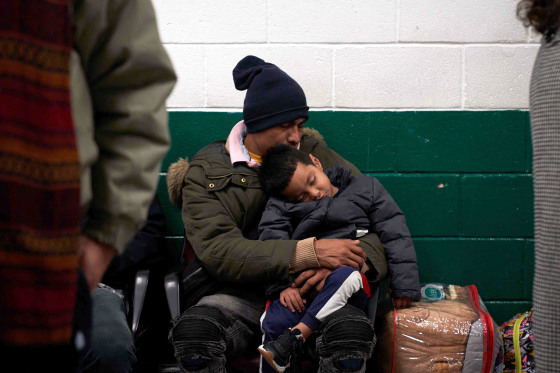 A migrant sleeps with his child while waiting in the local bus station in El Paso, Texas, on December 21, 2022. - The southern border of the United States has been officially closed to immigrants without visas for more than two years under a controversial health measure invoked by then-president Donald Trump during the Covid-19 pandemic. Title 42 prevents asylum seekers from presenting themselves at ports of entry, allowing border patrol officers to turn them away without starting an asylum application.