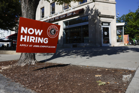 A "Now Hiring" sign is displayed in front of a Chipotle restaurant in Washington