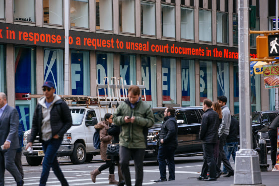 People walk passed the News Corp building