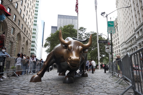 Tourists line up by the Charging Bull Statue