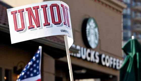 A protester waves a union sign near the Country Club Plaza Starbucks