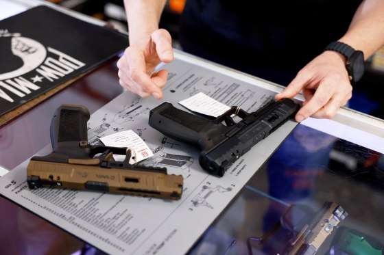 Two handguns sit on the counter of a gun store.