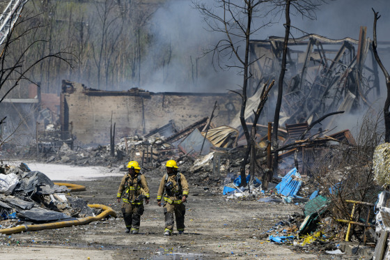 Firefighters walk out of the site of an industrial fire in Richmond, Ind., on April 12, 2023.