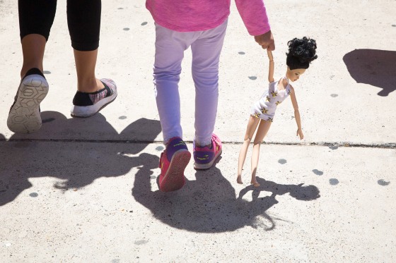 A 4-year-old Honduran girl carries a doll while walking with her immigrant mother, both released from detention through the "catch and release" policy, from a Catholic Charities relief center to a nearby bus station on June 17, 2018 in McAllen, Texas.
"Catch and release" is a protocol under which people detained by US authorities as unlawful immigrants can be released while they wait for a hearing.