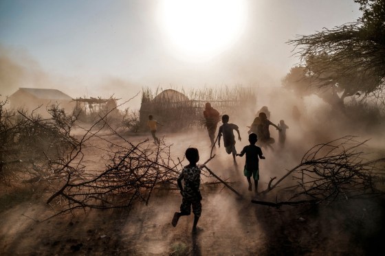 Children and women run through a cloud of dust in the village of El Gel, Ethiopia, on Jan. 12, 2023. The last five rainy seasons since the end of 2020 have failed, triggering the worst drought in four decades in Ethiopia, Somalia and Kenya.