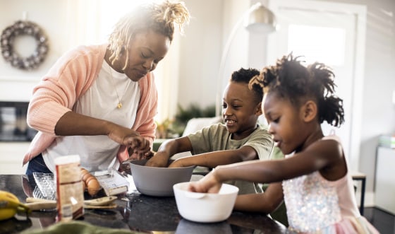 Mother and kids mixing cookie dough at home.