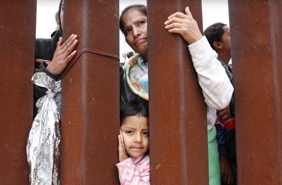 Ecuadorian mother Miriam stands with her daughter Aylin, 4, as they await volunteer assistance while stuck in a makeshift camp between border walls on May 13, 2023 in San Diego.