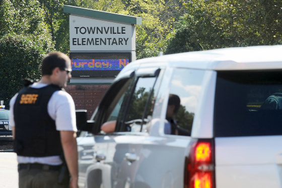Members of law enforcement talk in front of Townville Elementary School on Wednesday, Sept. 28, 2016, in Townville, S.C. A teenager opened fire at the South Carolina elementary school Wednesday, wounding two students and a teacher before the suspect was taken into custody, authorities said. (AP Photo/Rainier Ehrhardt)