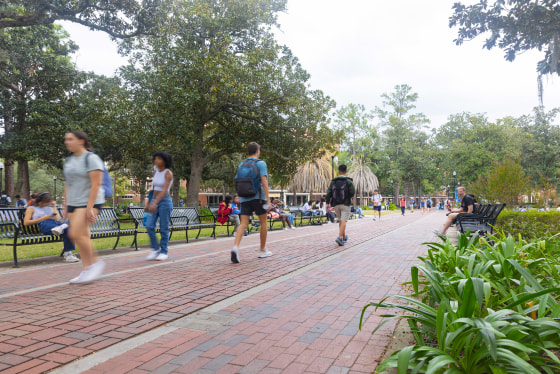 Students walk along a footpath at the University of Florida campus in Gainesville.