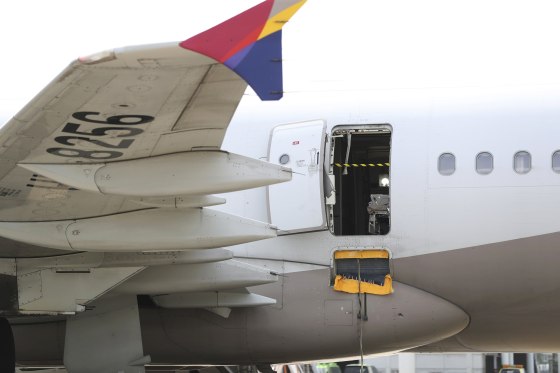 An emergency door hangs open on an Asiana Airlines plane at Daegu International Airport
