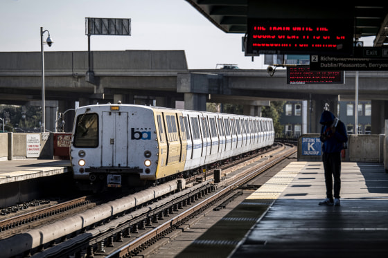 A person waits on a platform at a Bay Area Rapid Transit (BART) train station in Oakland, Calif., on Oct. 26, 2020.