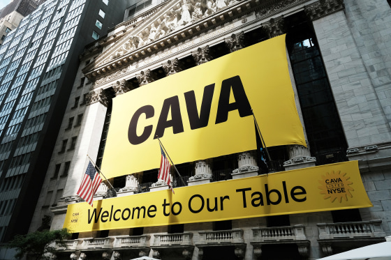 NEW YORK, NEW YORK - JUNE 15: A banner for the Mediterranean restaurant chain Cava is displayed outside of the New York Stock Exchange (NYSE) as the company goes public on June 15, 2023 in New York City. Cava priced its IPO at $22 per share, valuing the company at $2.5 billion.
