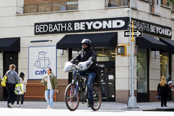A person bikes past a closed Bed Bath & Beyond