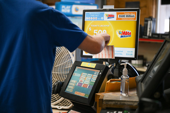 A cashier inserts lottery tickets at a gas station in Trona, Calif.