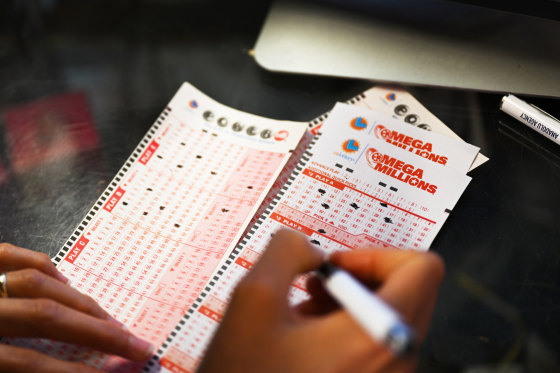 A close up on a powerball and mega millions ticket as a person plays the lottery