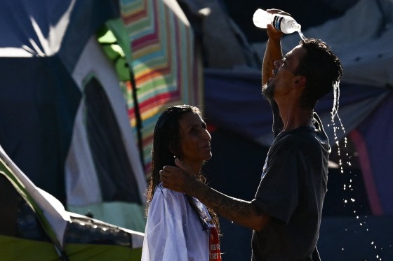 People try to cool off from extreme heat in "The Zone," a vast homeless encampment where hundreds of people reside, during a record heat wave in Phoenix on July 19, 2023.
