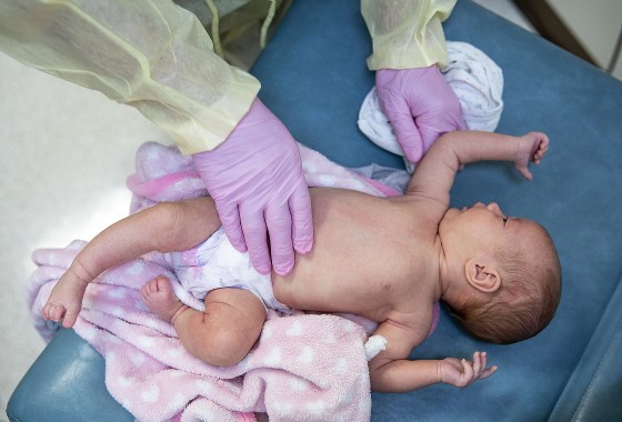 Image: A doctor examines a baby with respiratory symptoms in Cloquet, Minn., in 2020. The baby was tested for the flu, Covid-19, and RSV.