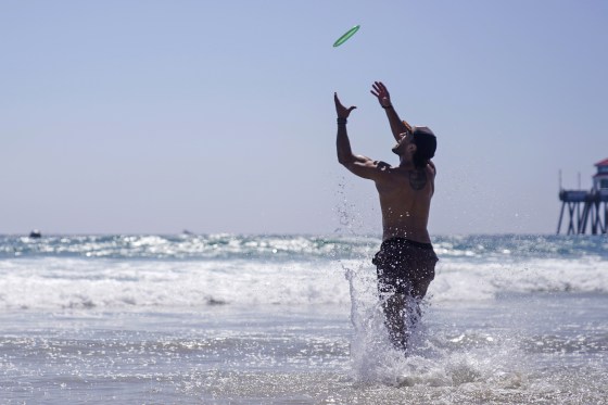 A man catches a flying disc on Aug. 5, 2023, in Huntington Beach, Calif.