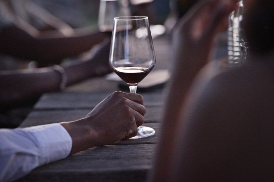 Hand of young man holding red wine glass