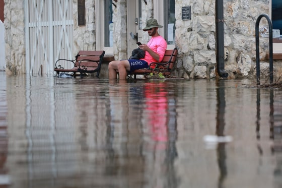 A man sits on a bench in floodwaters after Hurricane Idalia passed offshore on Aug. 30, 2023 in Crystal River, Fla.