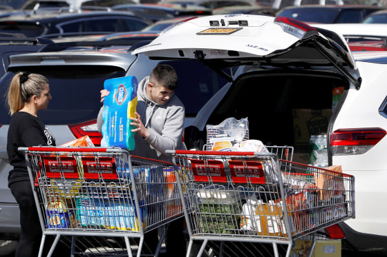 People load Clorox into their car in the Costco parking lot after the first confirmed case of coronavirus was announced in New York State, in the Brooklyn