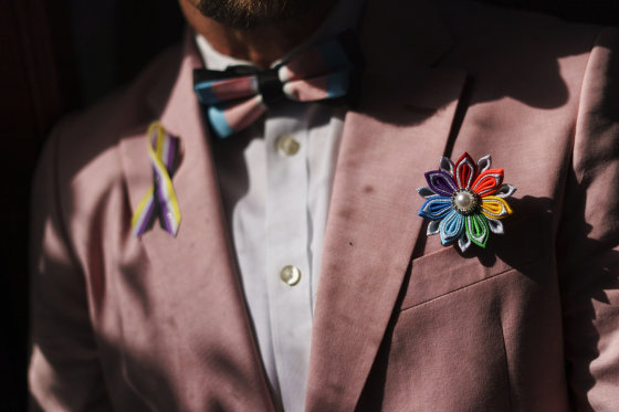 A rainbow flower sits in the jacket pocket of Scout, a transgender man who uses one name, at his home in Providence, R.I.