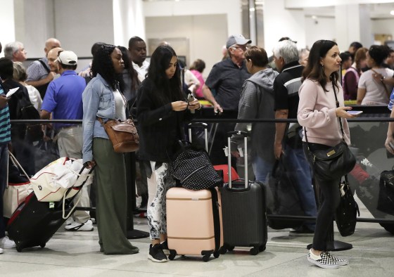 Passengers wait in line at a security checkpoint at Miami International Airport in Miami amid a government shutdown in 2019.