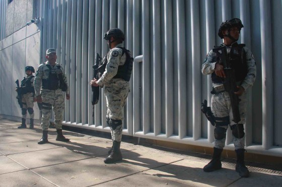 Image: Federal forces outside the Special Prosecutor's Office as a convoy carrying Ovidio Guzman, the son of drug trafficker 'El Chapo,' takes him to prison on Jan. 5.
