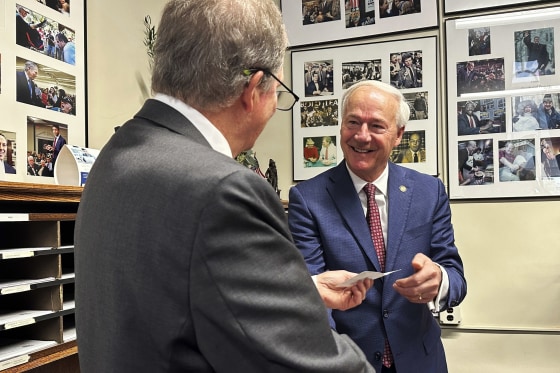 Former Gov. Asa Hutchinson pays the filing fee to get on the Republican ballot for the New Hampshire primary